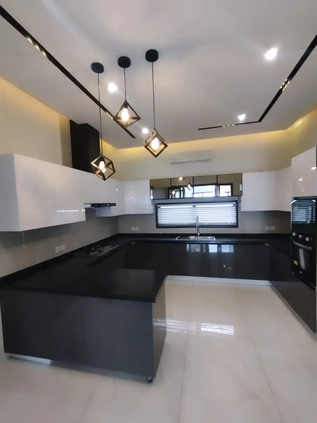 Premium U-Shaped Modern Kitchen – 1 Kanal House for Sale Lake City M3 Large U-shaped kitchen with black granite countertops white cabinets and pendant lights in Lake City M3 Lahore