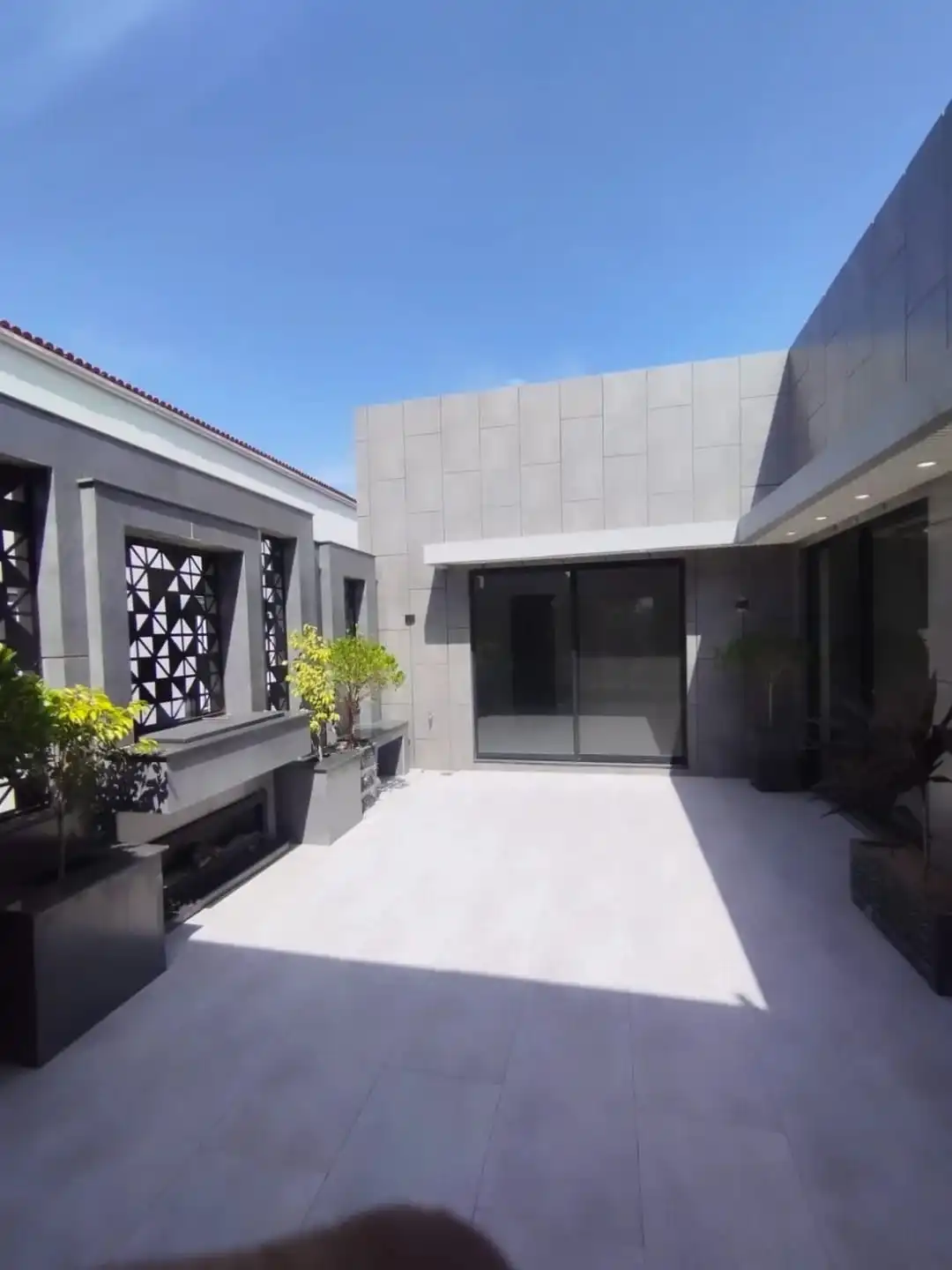 Elegant Outdoor Courtyard – 1 Kanal Signature Residence Lake City M3 1 Kanal luxury house courtyard with modern tiles and sliding glass door in Lake City M3 Lahore