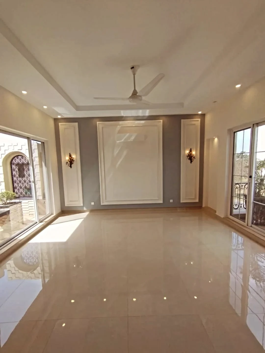 Sophisticated Drawing Room – 1 Kanal House for Sale Block M2 Lake City Elegant drawing room with cream marble flooring, grey feature wall and wall sconces in 1 Kanal house Lake City Lahore
