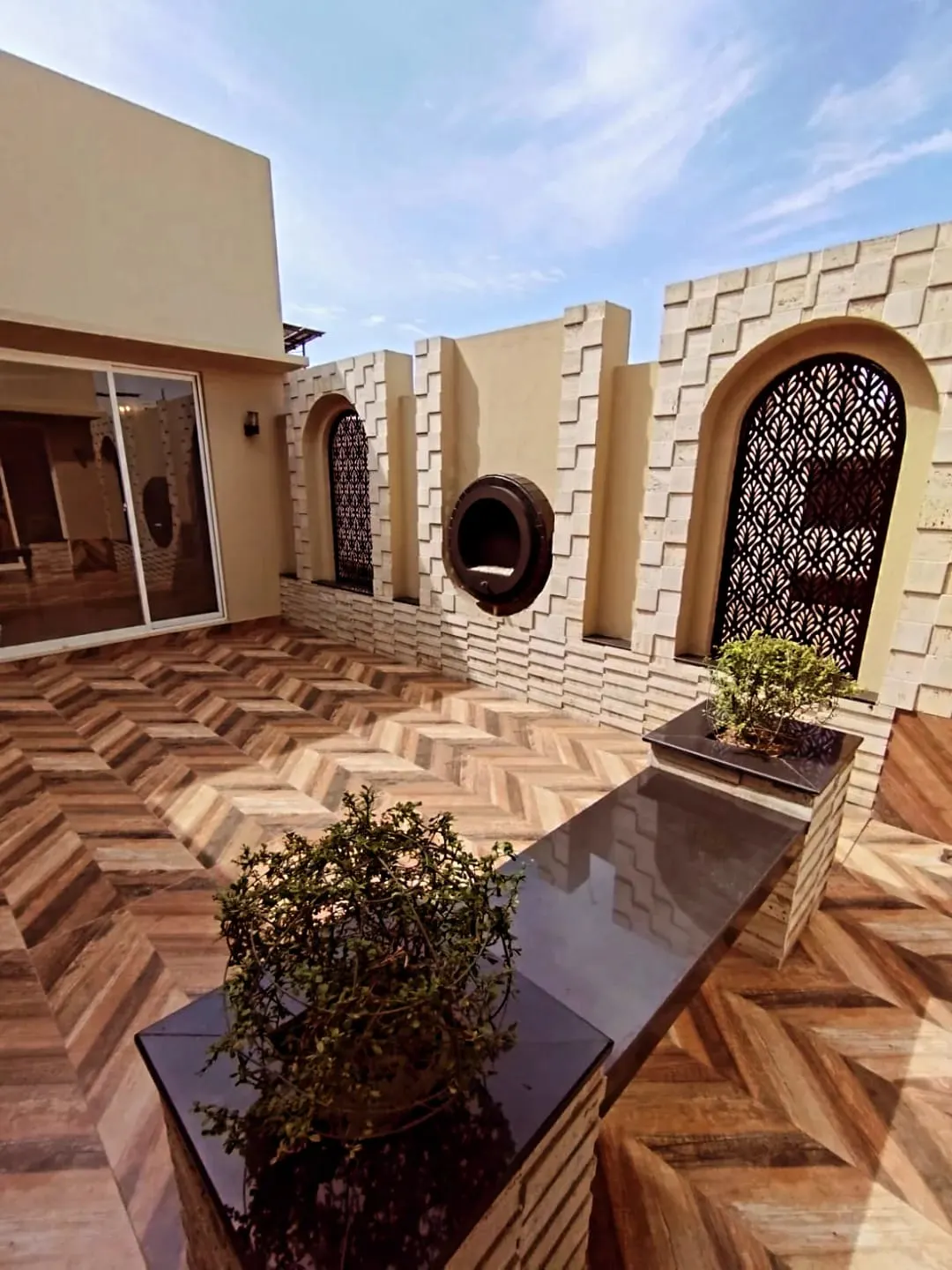 Luxury Outdoor Courtyard – 1 Kanal House for Sale Lake City M2 Lahore Spacious terrace with herringbone tile flooring and Arabic arch design in 1 Kanal house Block M2 Lake City Lahore