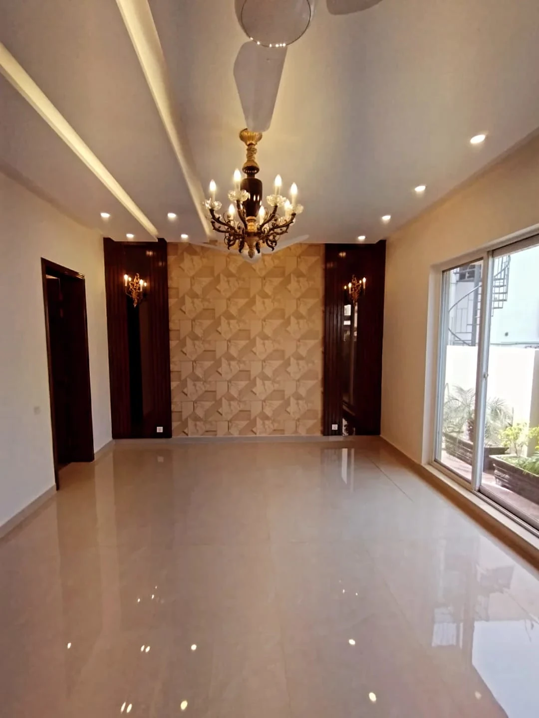 Elegant TV Lounge – 1 Kanal House for Sale Block M2 Lake City Lahore Spacious TV lounge with textured stone feature wall, chandelier and marble flooring in 1 Kanal house Block M2 Lake City