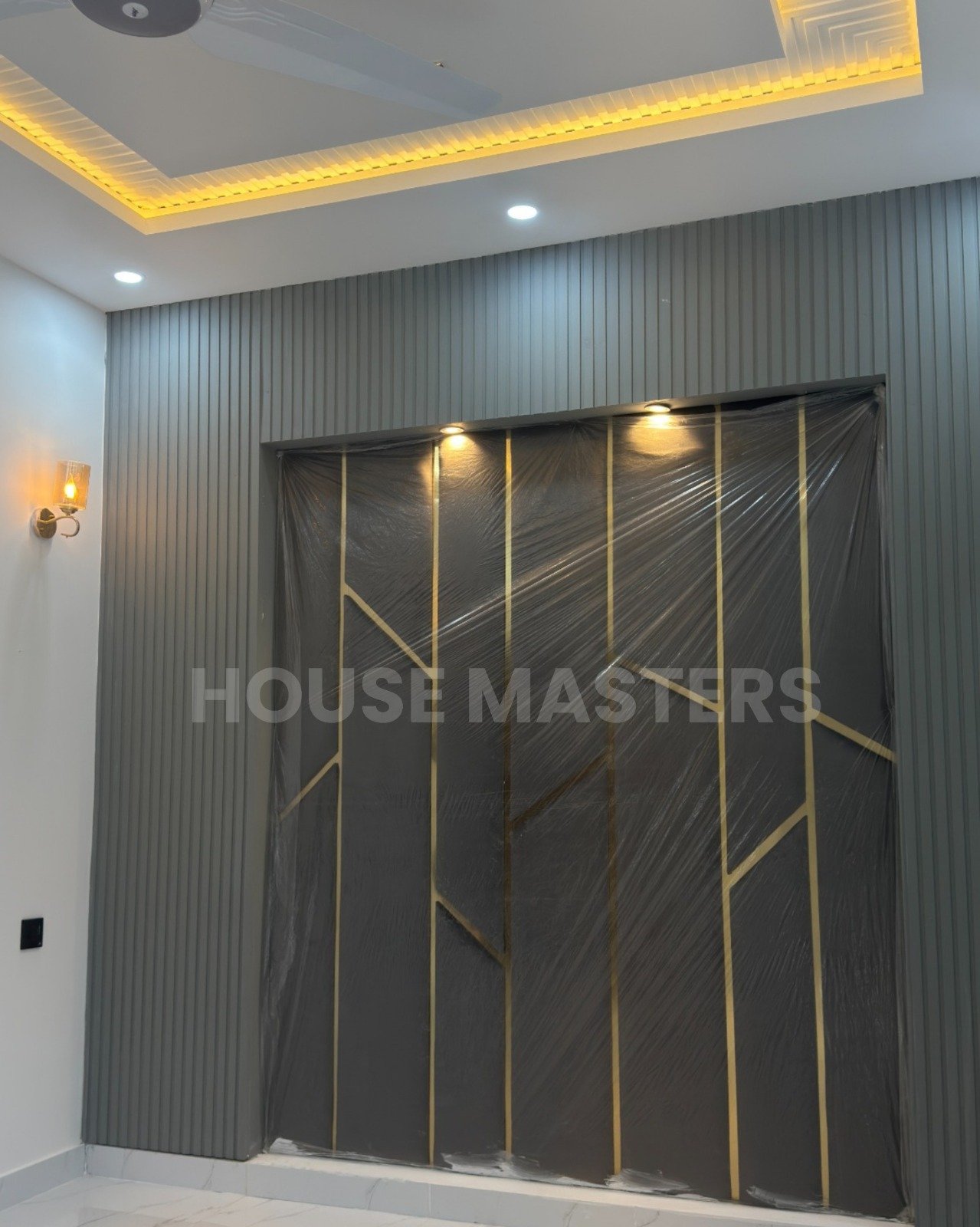 Modern interior feature wall with grey panels, gold accents, and built-in spotlights in 5 Marla luxury home, Bahria Orchard