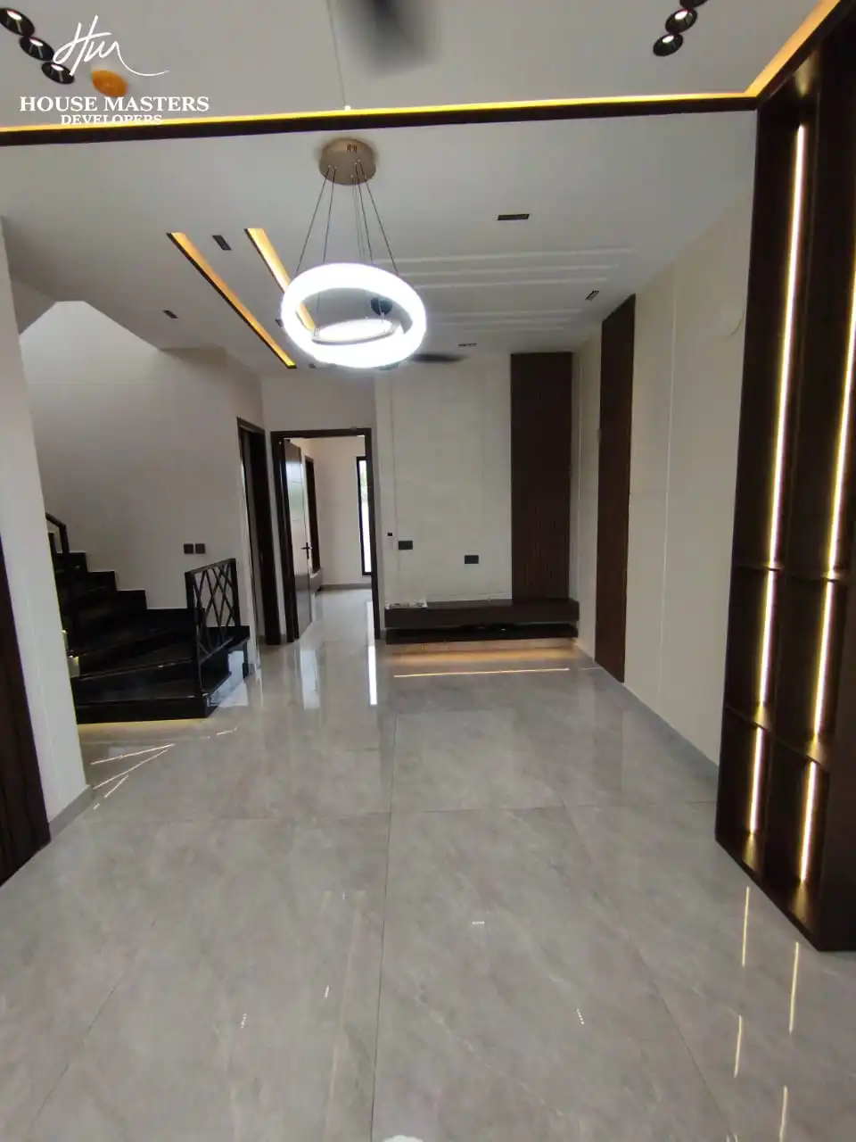 5 Marla Modern House for Sale in DHA Rahber Lahore Spacious upper floor TV lounge room with dark wood panel accents