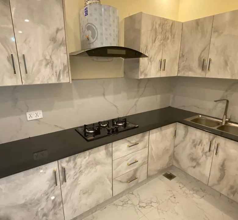 Fully fitted kitchen with custom grey marble texture cabinets and stove top in 5 Marla home.