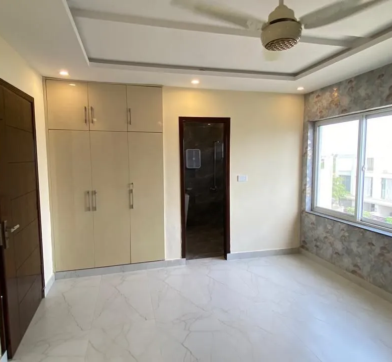 Modern lobby, tiled flooring, and under-stairs storage cabinets of a brand new 5 Marla home.