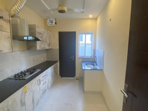 Modern bathroom with premium marble tiles, floating vanity, and round mirror in Lake City Lahore M8 house.